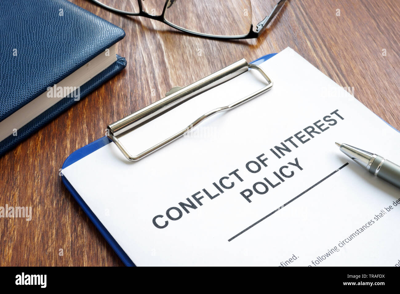 Conflict of interest policy and pen on a wooden surface. Stock Photo