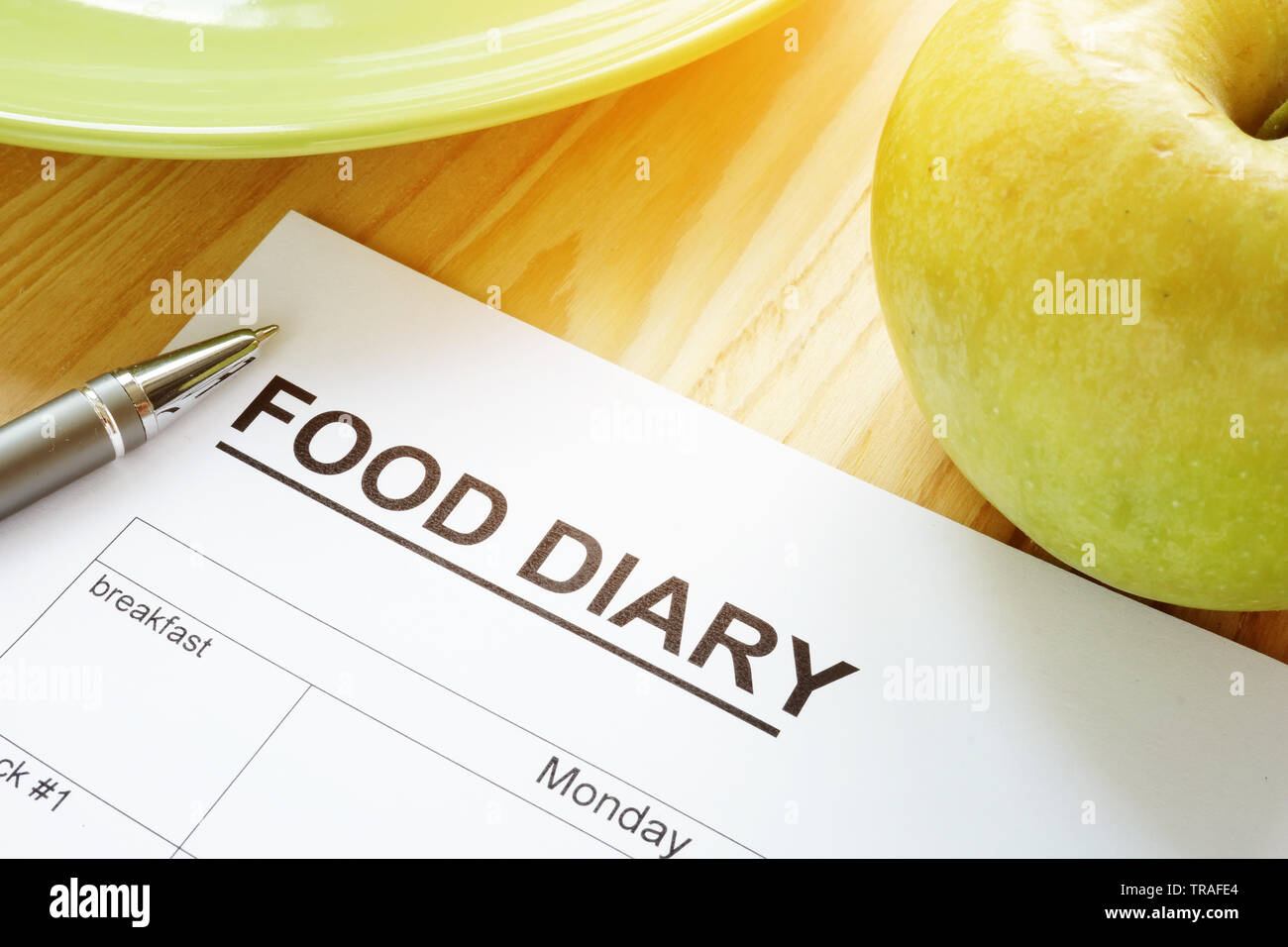 Food diary or meal plan and an apple. Stock Photo
