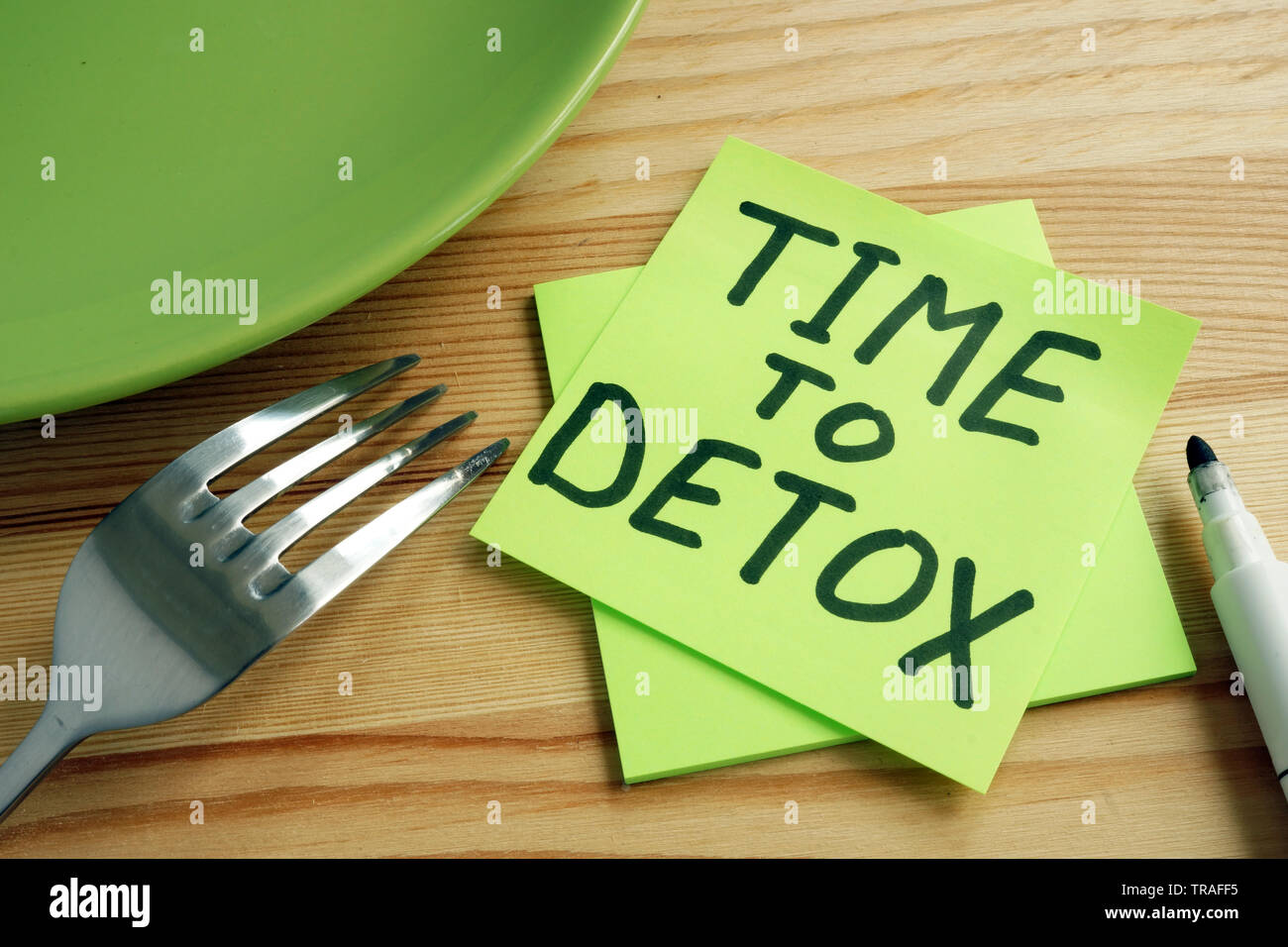 Time to detox concept. Fork and green plate on table. Stock Photo