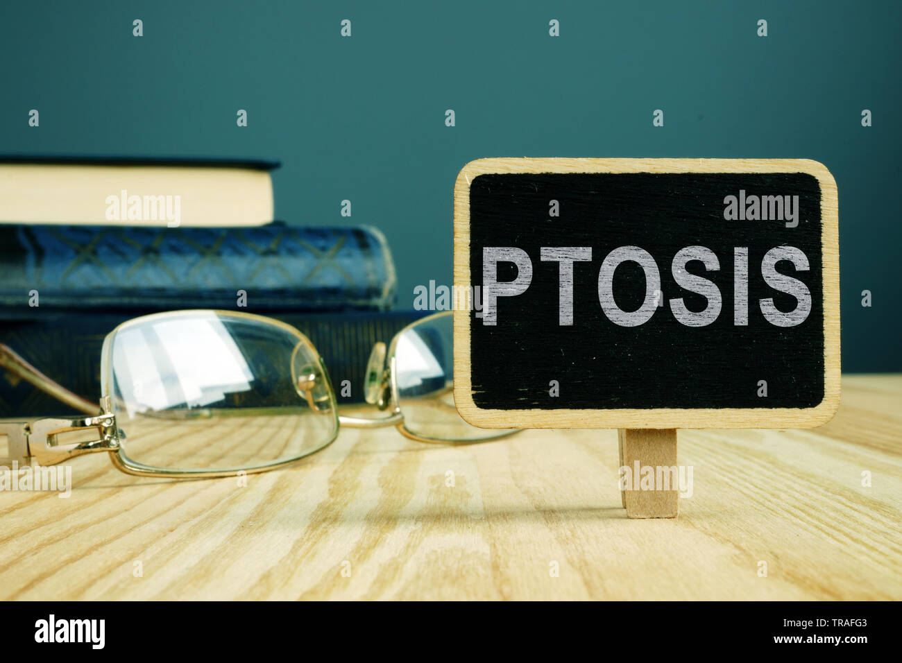 Ptosis disease. Eye glasses and book on desk. Stock Photo