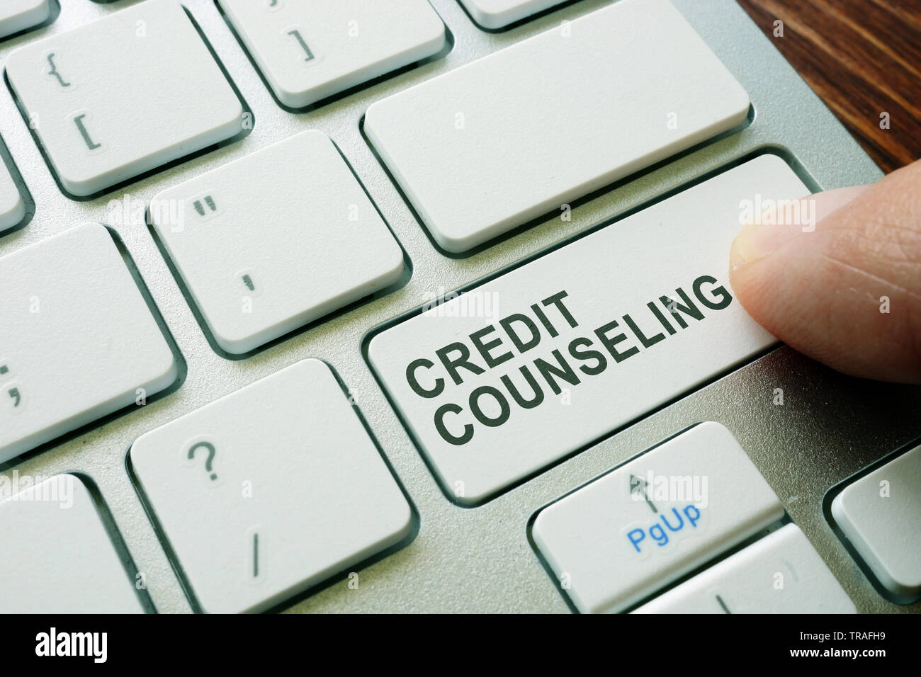 Man pushing button credit counseling on keyboard. Debt advice. Stock Photo