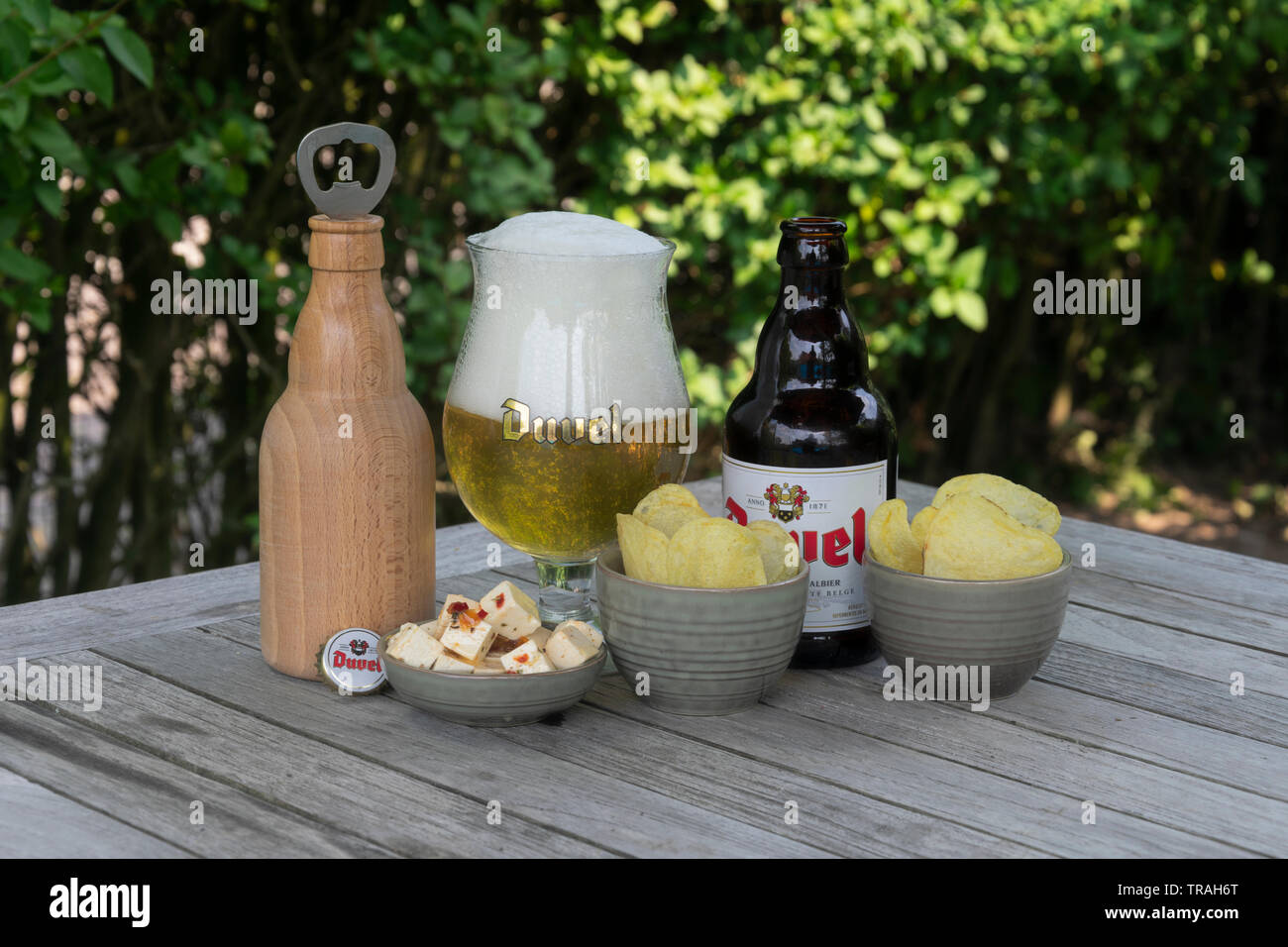Sint Gillis Waas, Belgium - july 22, 2018: Duvel, Belgium beer feta cheese and salted chips and a wooden bottle opener in the form of a bottle of duve Stock Photo