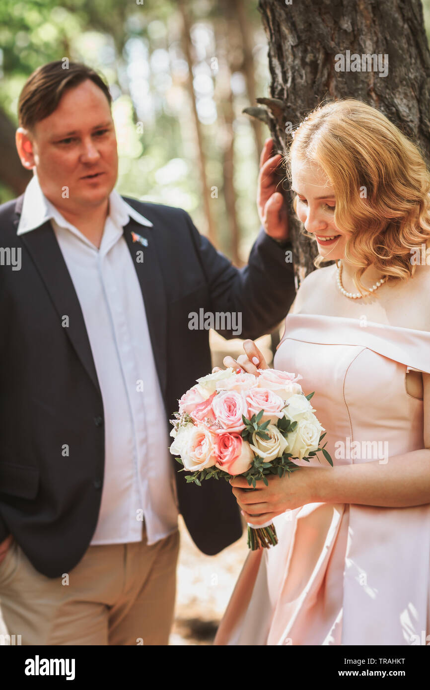 bride and groom kiss on the background of trees and forest Stock Photo ...