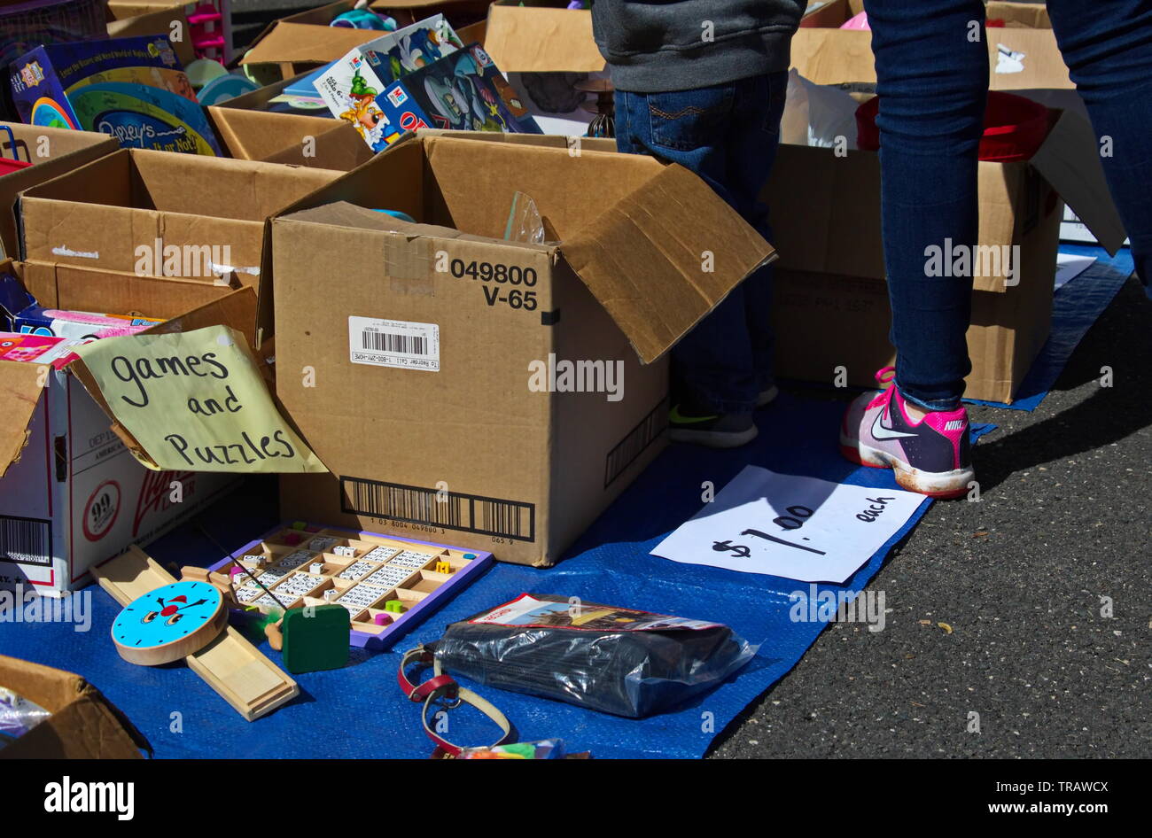 Middletown, Connecticut / USA - May 18, 2019: Mother and son looking through the boxes of toys on display at a yard sale Stock Photo
