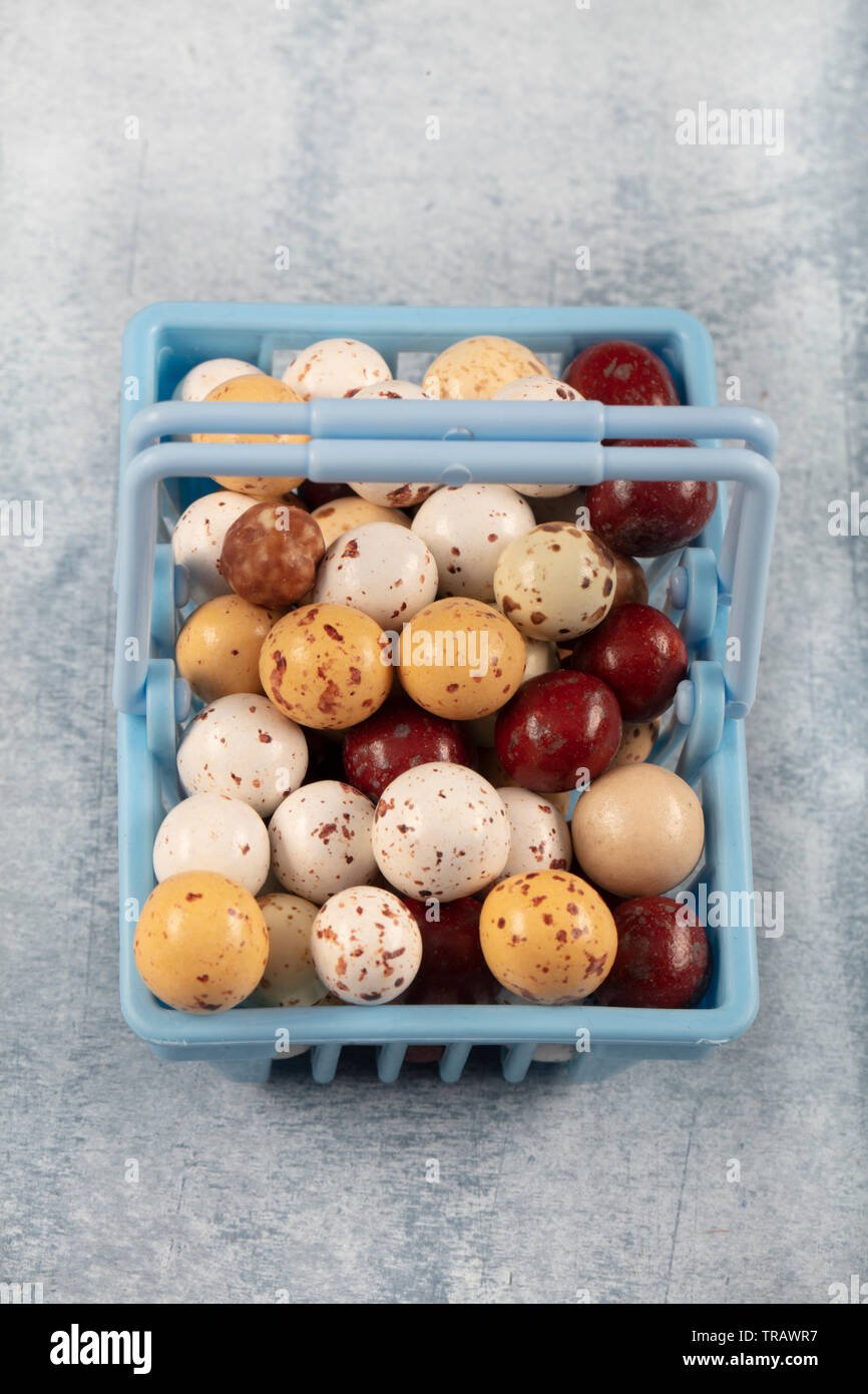 In shopping cart Candy Chickpeas; Roasted chickpeas covered in chocolate, fruit sauce in linen sack on wooden background. Stock Photo