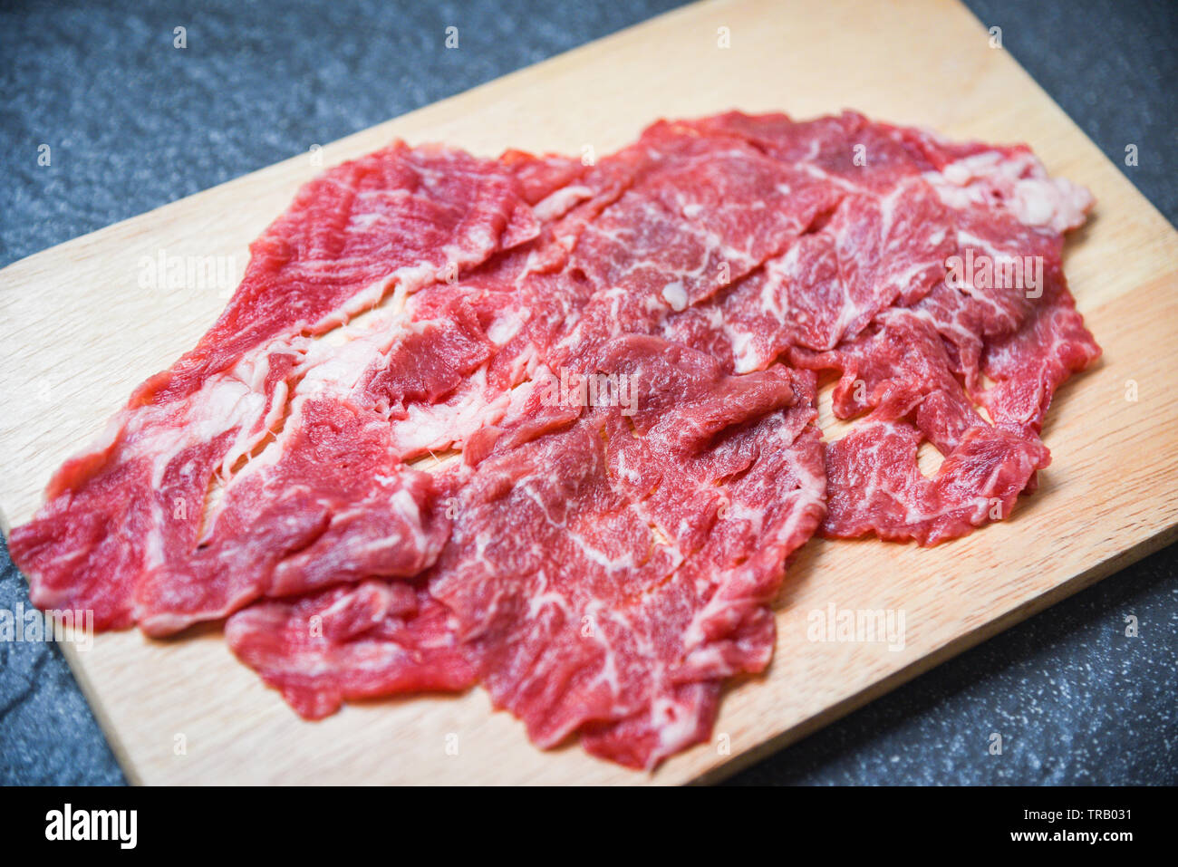 Meat beef slice on wooden cutting board for cooked or Sukiyaki Shabu