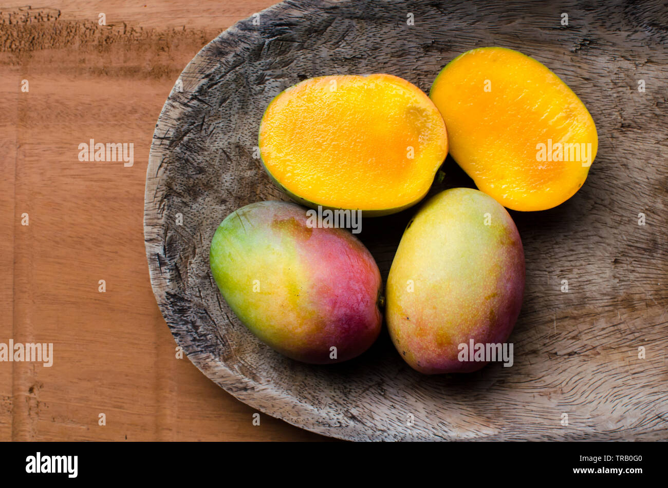 Ripe mangoes on a rustic table background Stock Photo