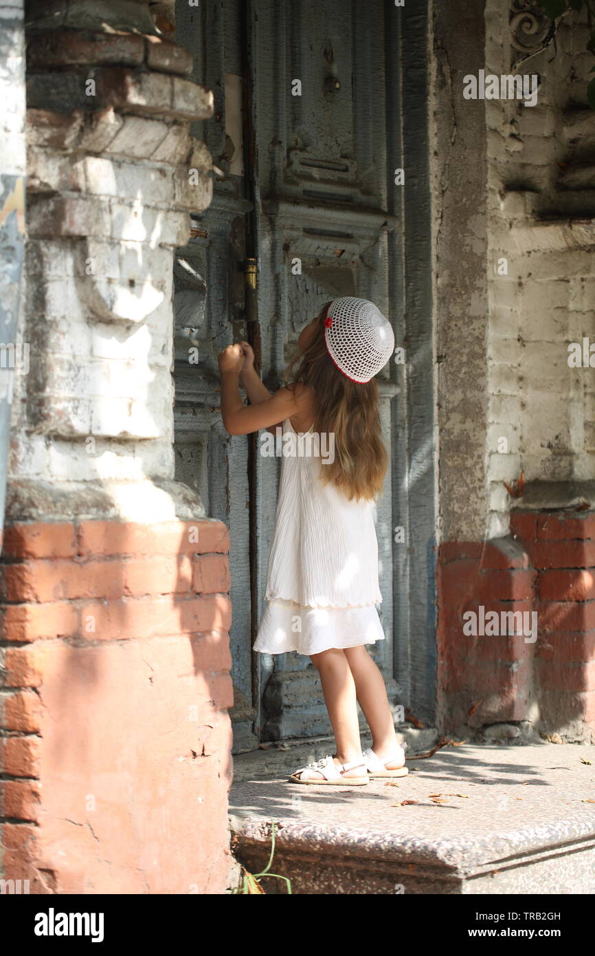 Little girl stands in front of the door Stock Photo - Alamy