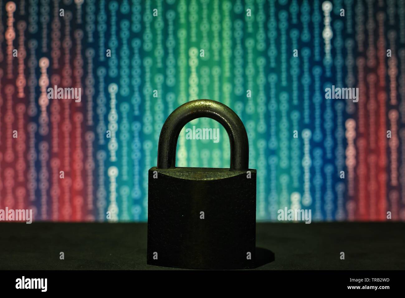 closed padlock in front of matrix style computer language binary data code. blue green binary surrendered by red code. protecting the user privacy aga Stock Photo