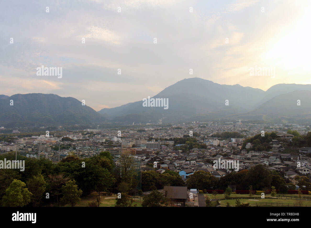 The landscape of Beppu in Oita and golf range as seen from a hill in sunset. Including the steam! Stock Photo