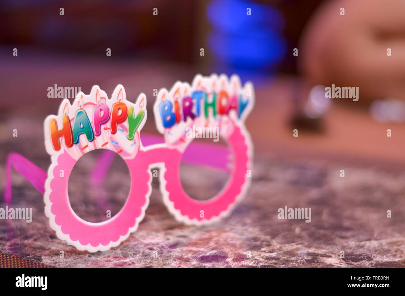 Pink goggles / specs made of cardboard / paper with happy birthday written on top. Stock Photo