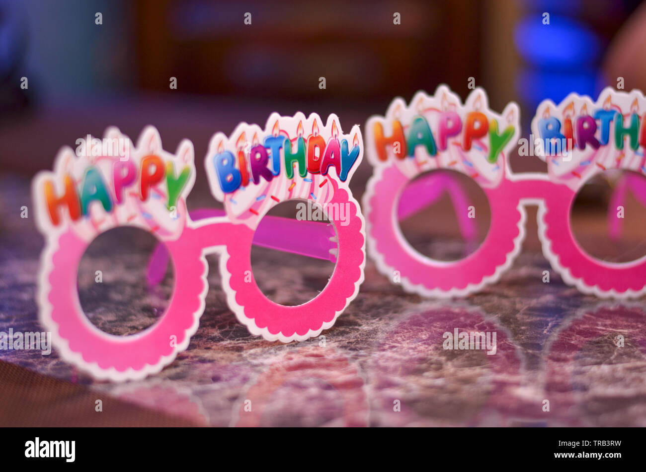 Pink goggles / specs made of cardboard / paper with happy birthday written on top. Stock Photo