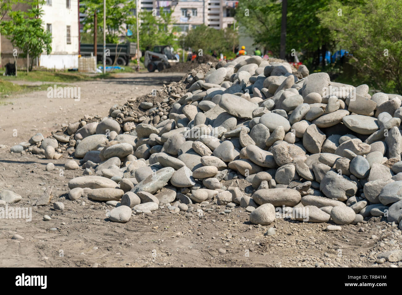 pile of rounded stones piled in the side of the road. stones for road