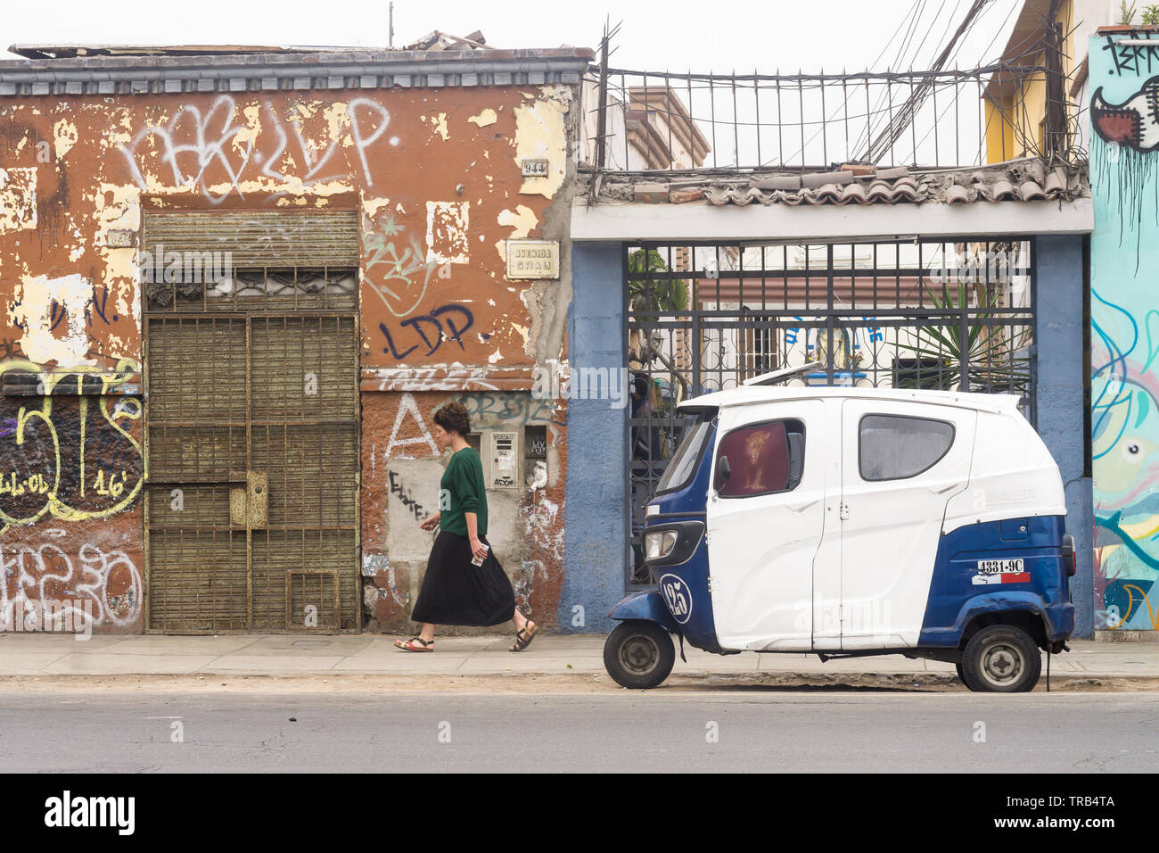 Barranco, Lima, street scene - woman walking past the mototaxi (Peruvian tuk tuk). Stock Photo