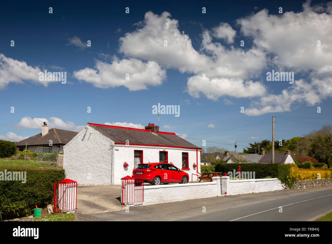 Ireland, Co Louth, Cooley Peninsula, Rooskey, red car parked in small cottage with red painted windows Stock Photo