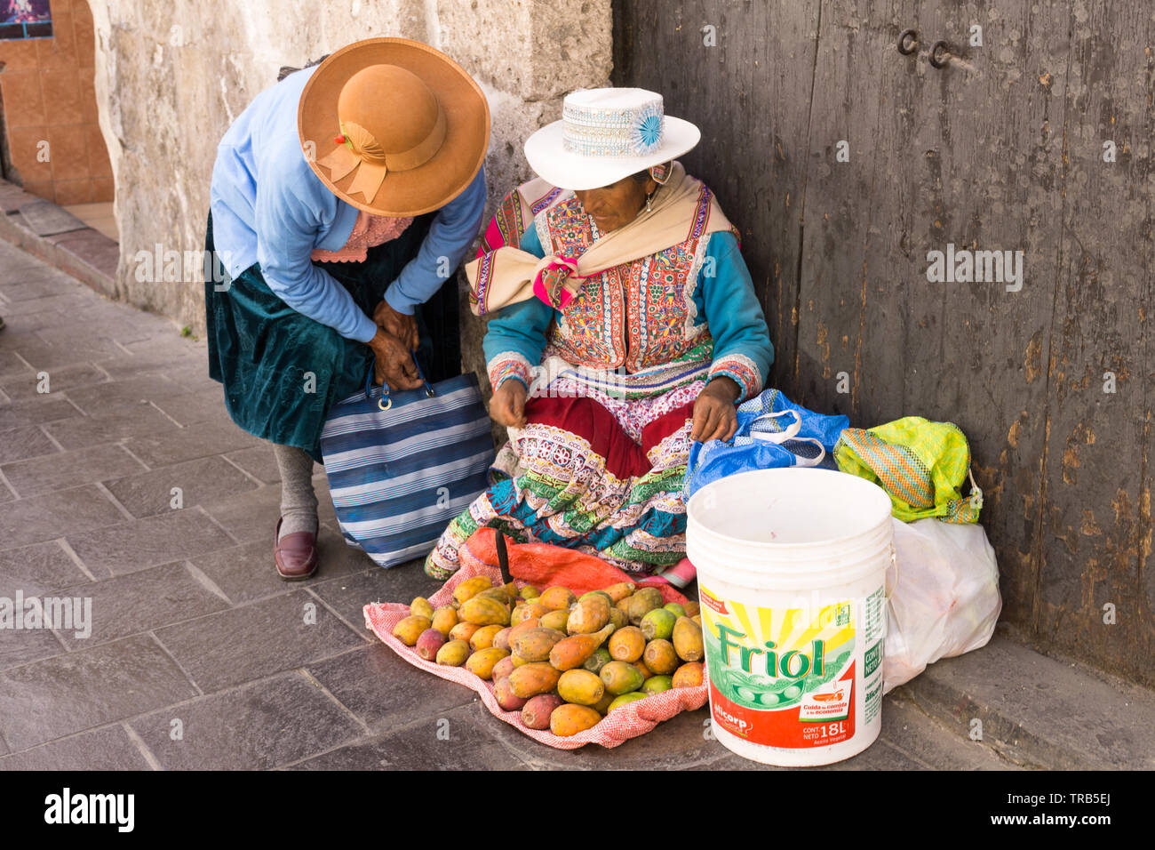 Peruvian women in traditional clothes selling fruits on the street of Arequipa, Peru. Stock Photo