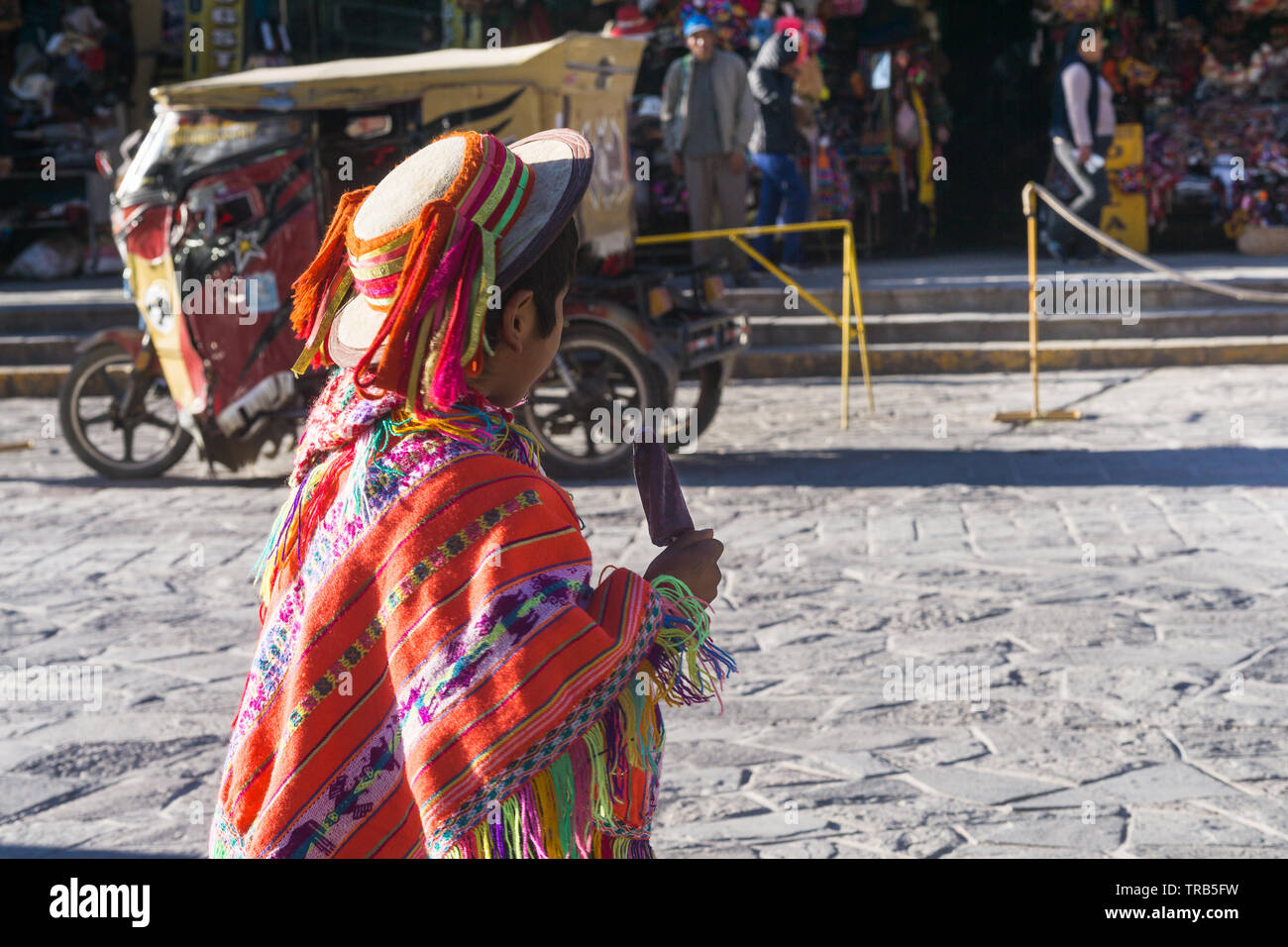 Peru boy traditional clothes - Peruvian boy wearing traditional clothes eats ice cream in Ollantaytambo, Peru, South America. Stock Photo