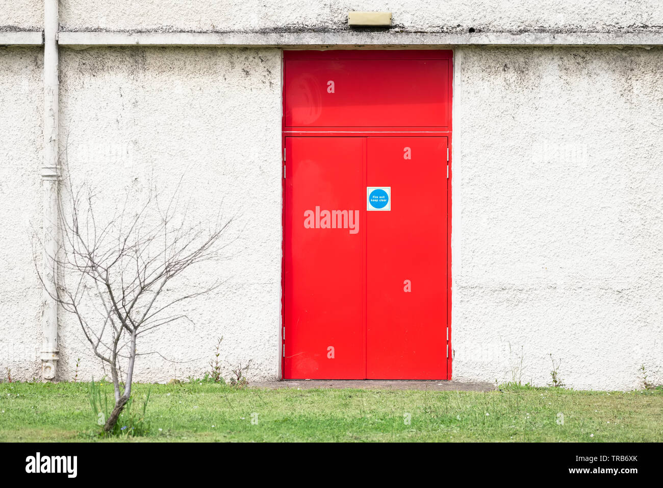 Fire Exit Red Door And White Wall At Work Place Stock Photo
