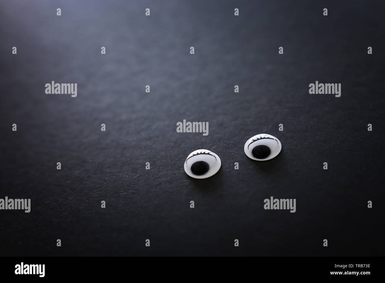 pair googly eyes over black background Stock Photo Alamy — free download