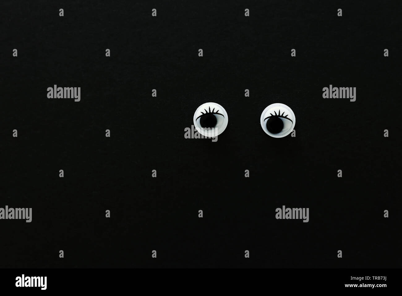 pair googly eyes over black background Stock Photo Alamy — free download