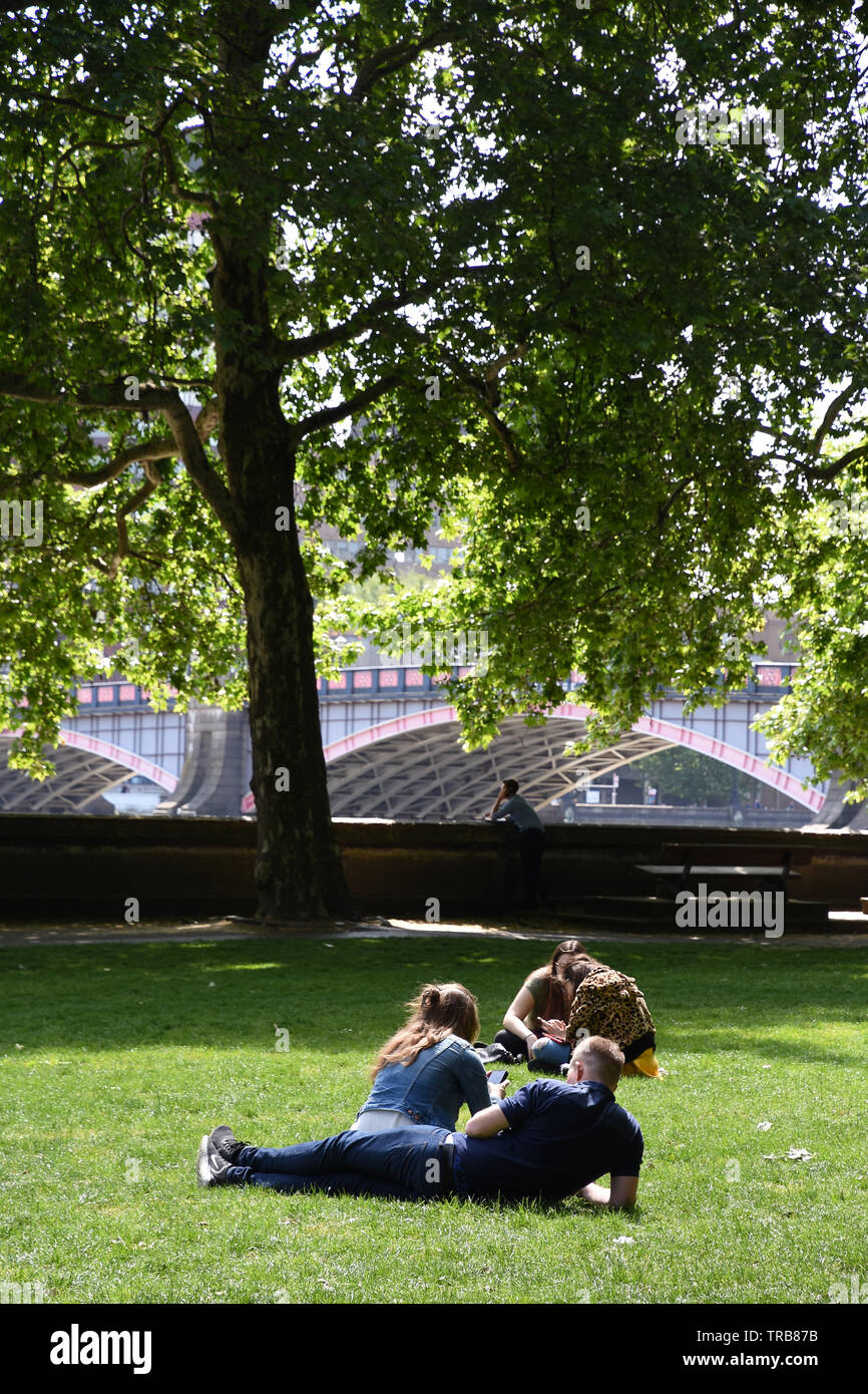 Couples enjoy the sunshine in Victoria Tower Gardens, Westminster, London. UK Stock Photo