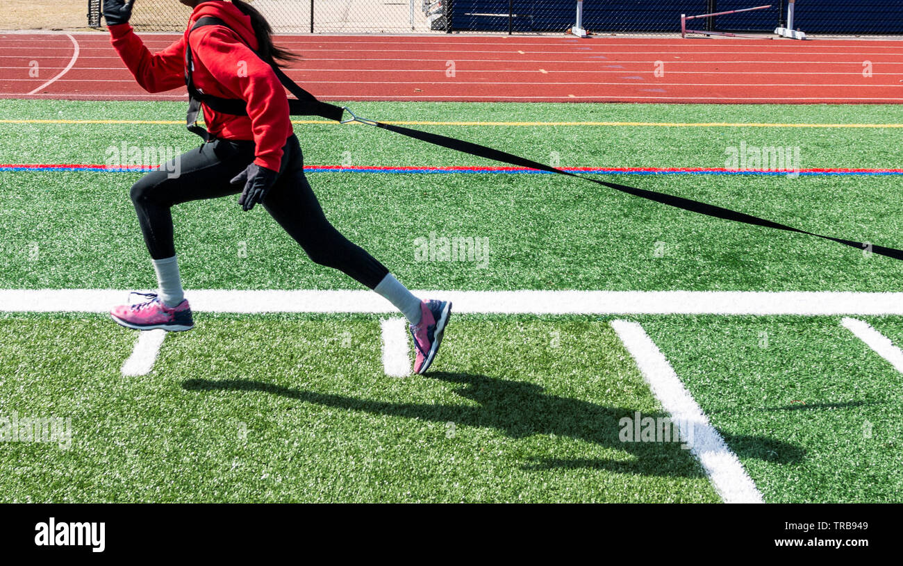 A high school teenage girl wearing a red sweatshirt, spandex and gloves