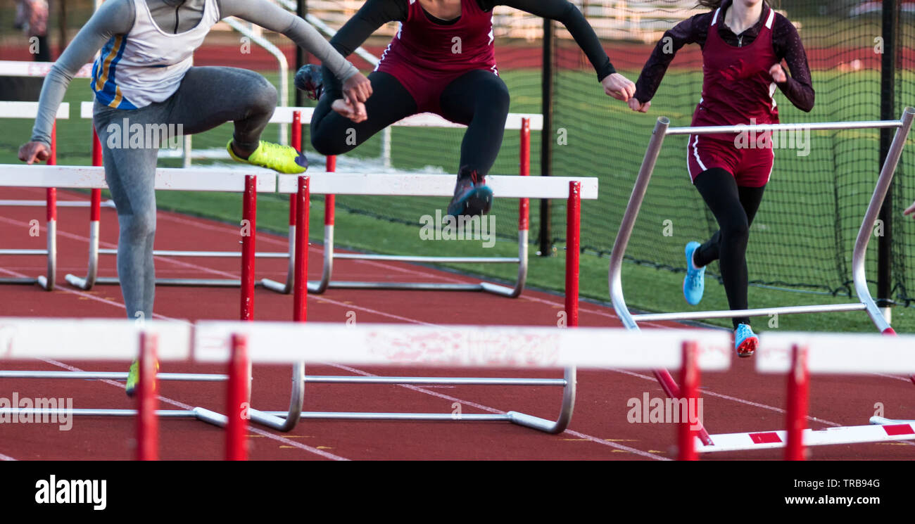 A high school hurdle race is run outdoors in the old early spring with