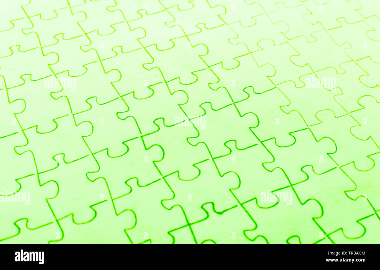 Assembled puzzle on a bright green background. Stock Photo