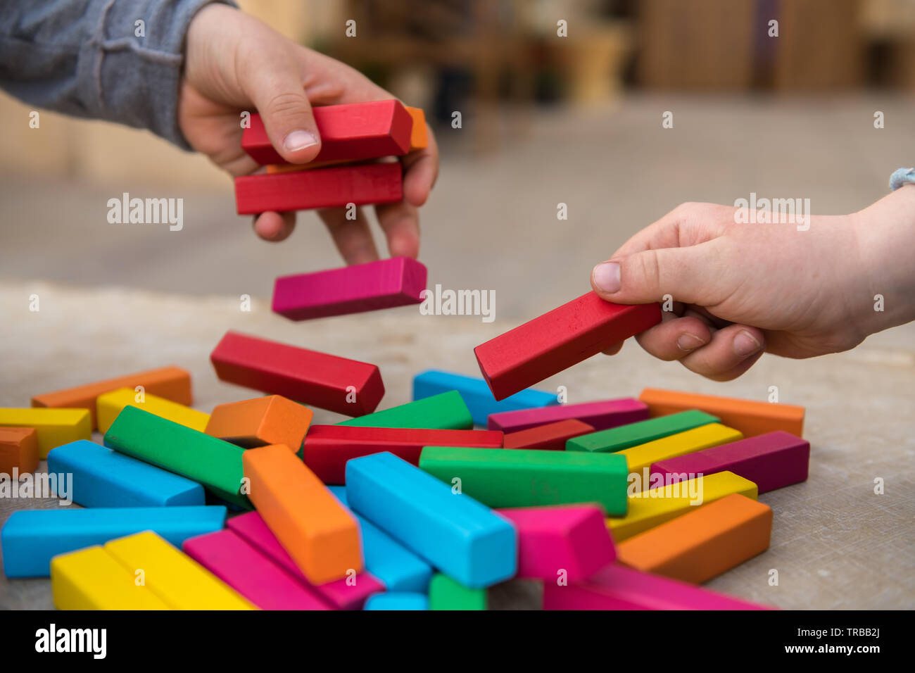 Children play with colored wooden blocks on a bench outdoors Stock ...