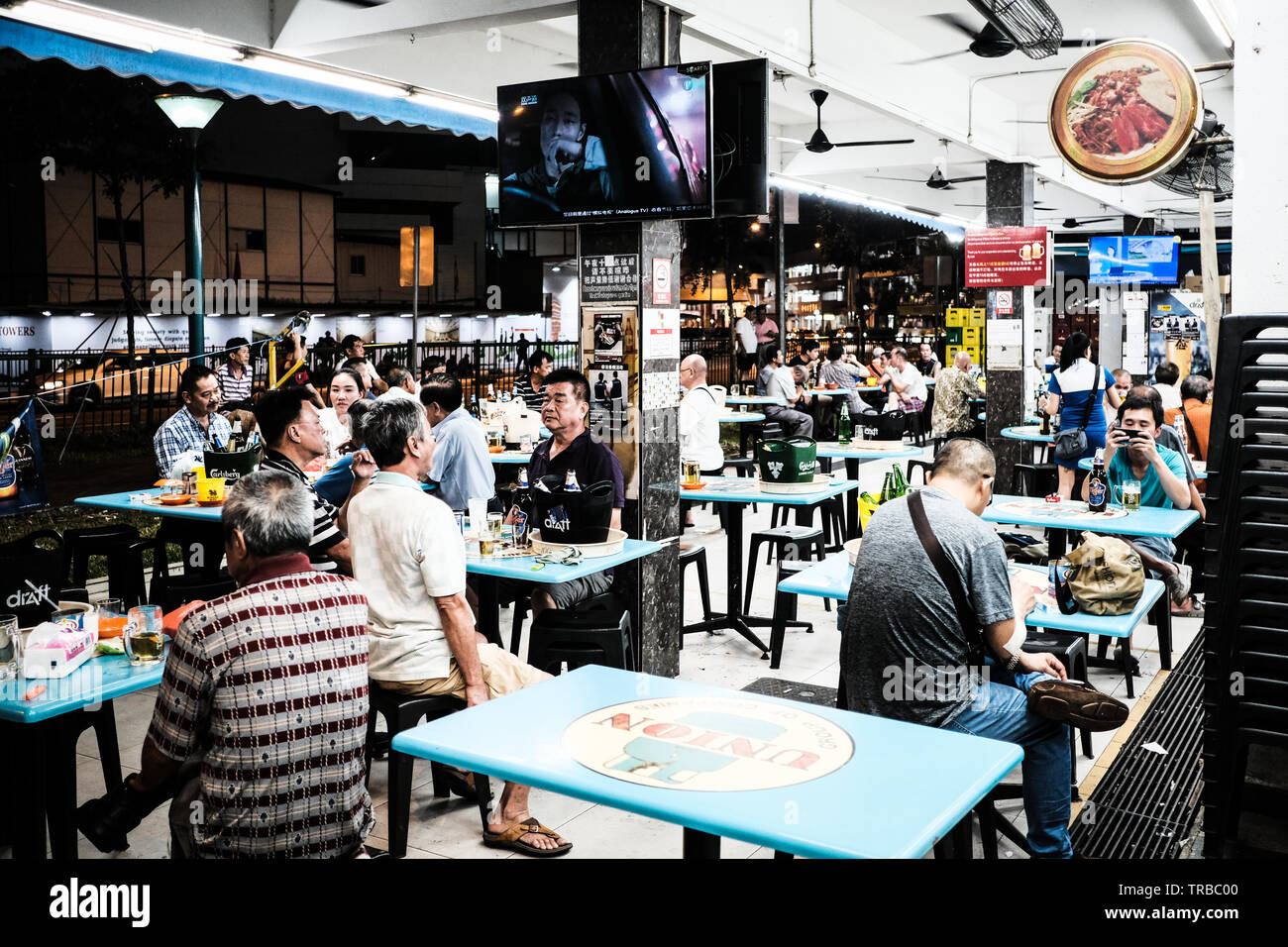 Singaporian Locals in a Hawker Centre at Night, Singapore Stock Photo