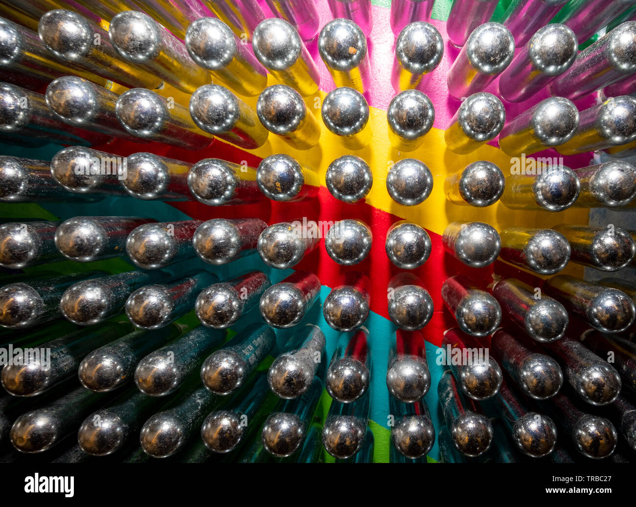 Empty laughing gas canisters reflecting colourful background. Metal