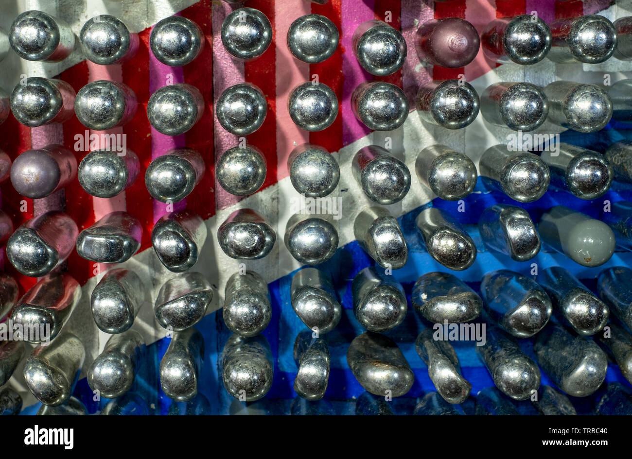 Empty laughing gas canisters reflecting colourful background. Metal