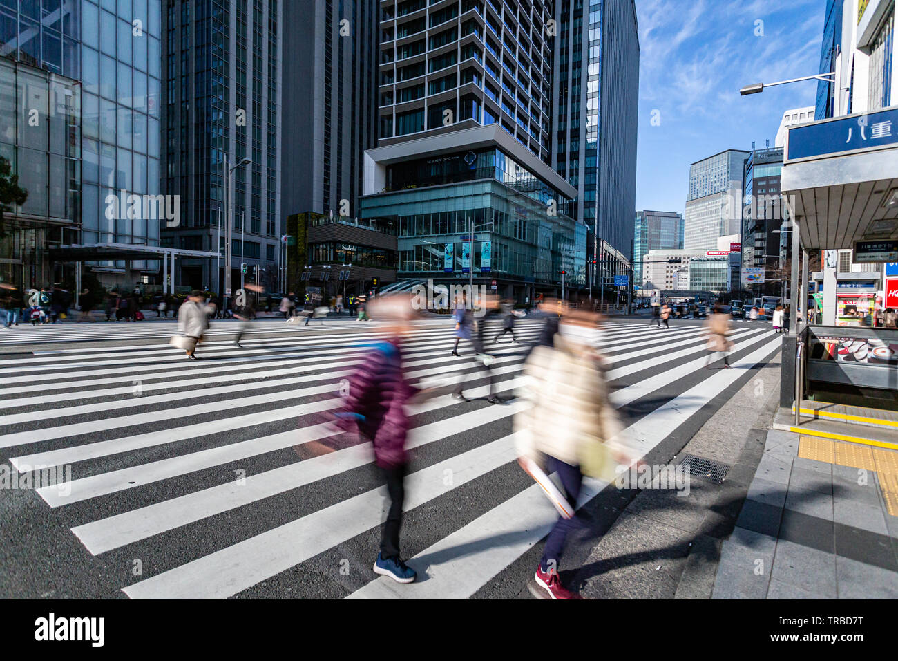 Tokyo, Japan - 23 February 2019 - Pedestrians walk cross a busy street ...