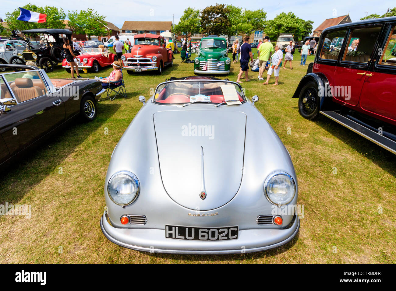 The 38th year of the annual bucket and Spade classic car run from Canterbury to Ramsgate seafront. Classic cars, old and modern, parked in rows on lawn with people walking around viewing them on bright sunny day. A early Porsche. Stock Photo
