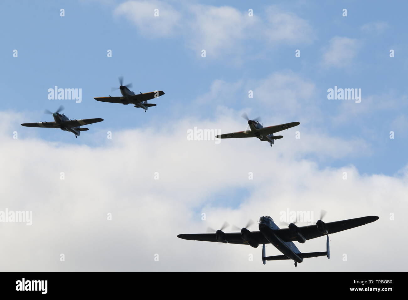 Lancaster Bomber , 2 hurricanes & a Spitfire flying formation Stock Photo