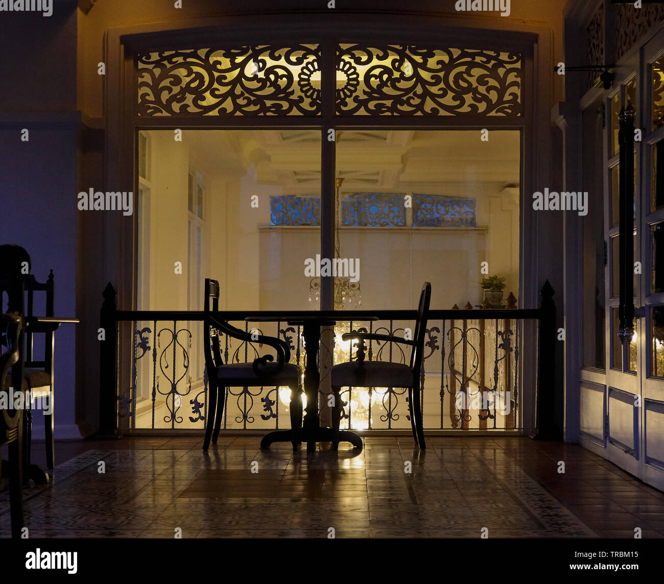 outdoor seating silhouetted against ornate window Stock Photo