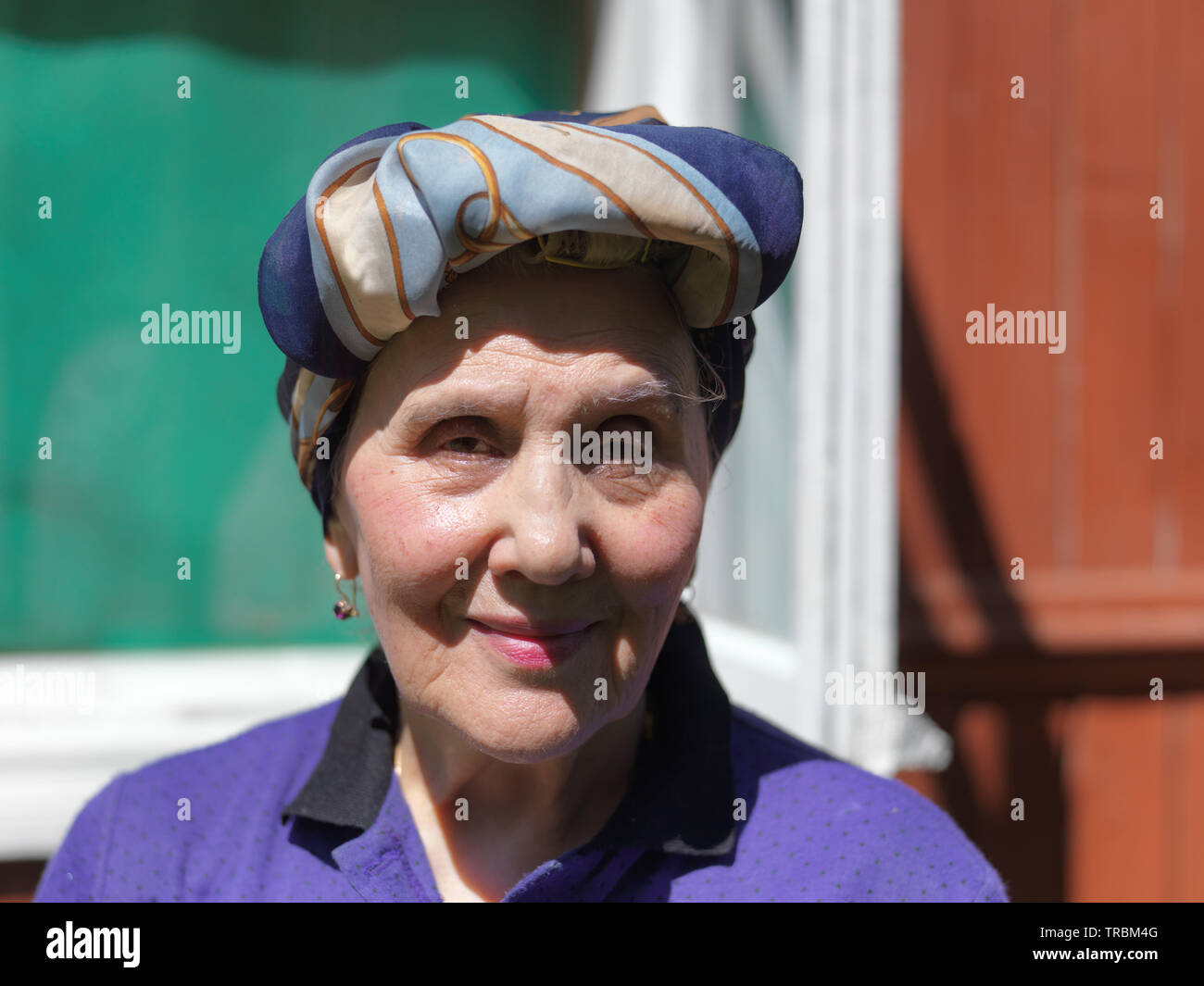 Senior female wearing head scarf on her head posing with a happy look outdoor Stock Photo