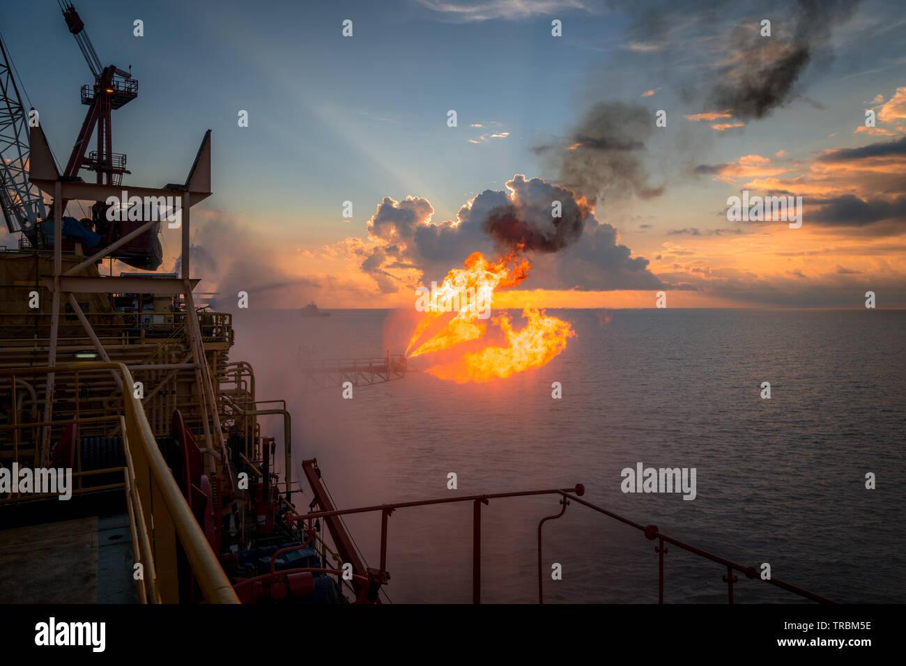 Well testing operation (flaring) of an oil and gas drilling rig. Burning huge gas flame controlled by the deluge system Stock Photo