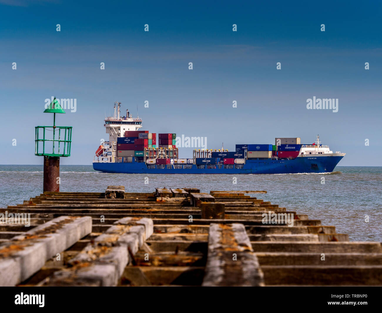 Container feeder ship Fenja entering Felixstowe container port. Feeder Vessel Fenja Felixstowe. Stock Photo
