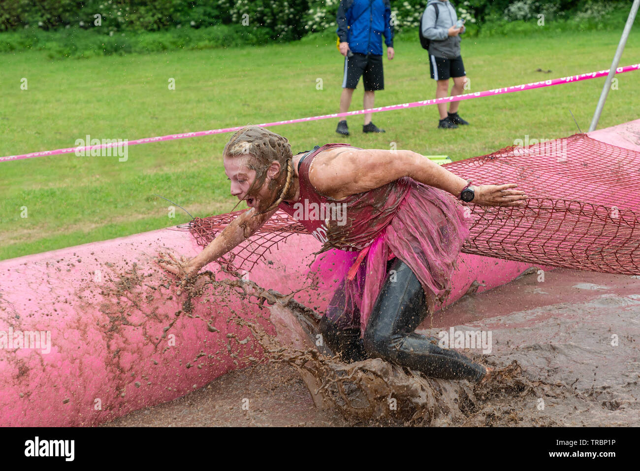 Warrington, UK. 2nd June 2019. Race for Life 2019, Warrington, in aid of Cancer Research. Woman getting wet and muddy in a mudpit Stock Photo