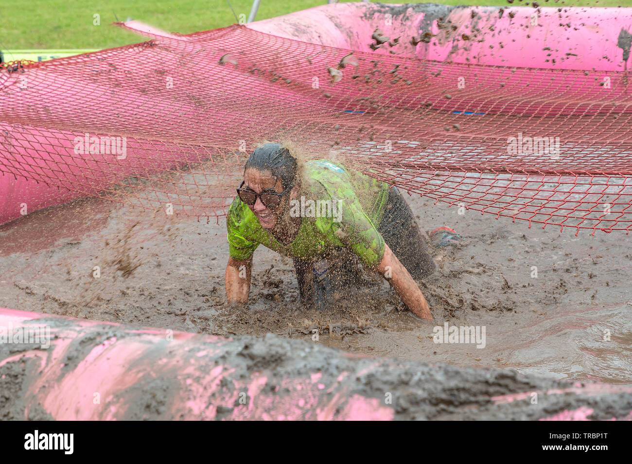 Warrington, UK. 2nd June 2019. Race for Life 2019, Warrington, in aid of Cancer Research. Woman getting wet and muddy in a mudpit Stock Photo