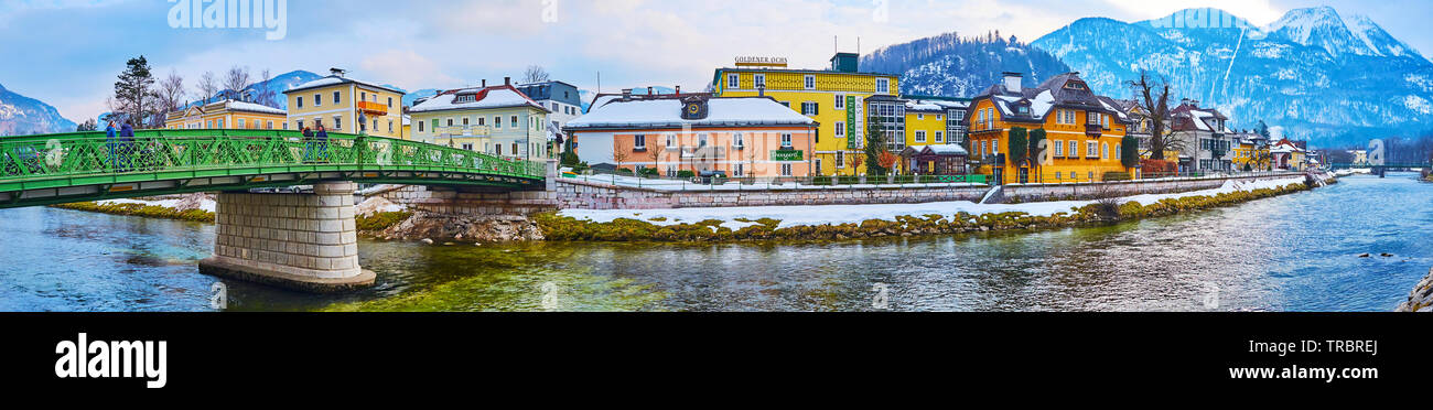 BAD ISCHL, AUSTRIA - FEBRUARY 20, 2019: Panorama with colorful buildings of old town stretch along the fast flowing Traun river, the snowy Mount Katri Stock Photo