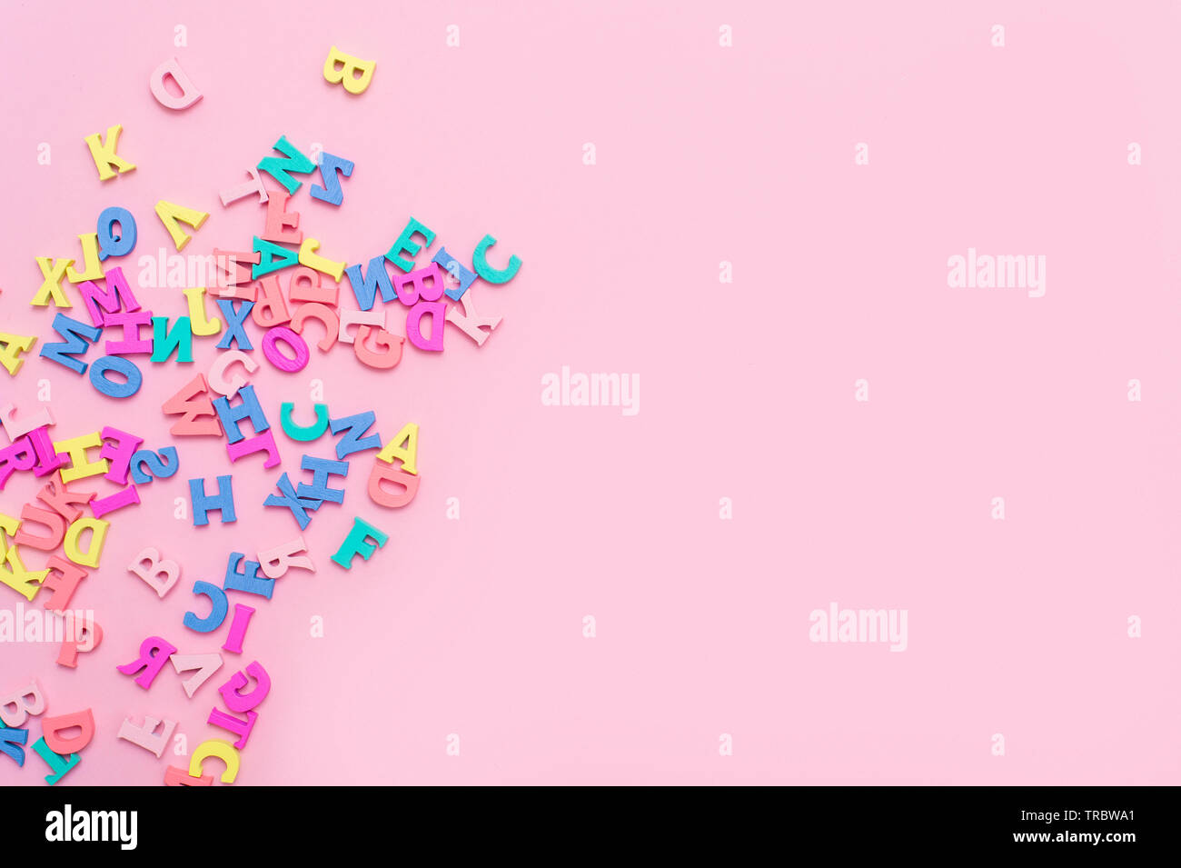 Many multicolored wooden letters on a pink background. toy letters. english  alphabet. View from above. Flat lay. Copy space for text Stock Photo - Alamy