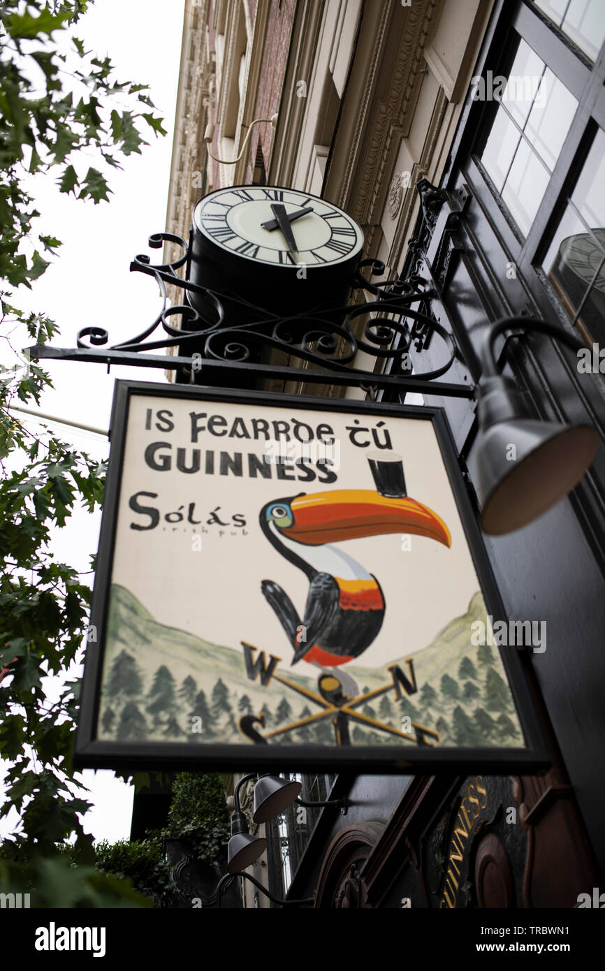 Clock and sign hanging outside the Solas Irish pub in the Lenox Hotel in the Back Bay neighborhood of Boston, Massachusetts, USA. Stock Photo