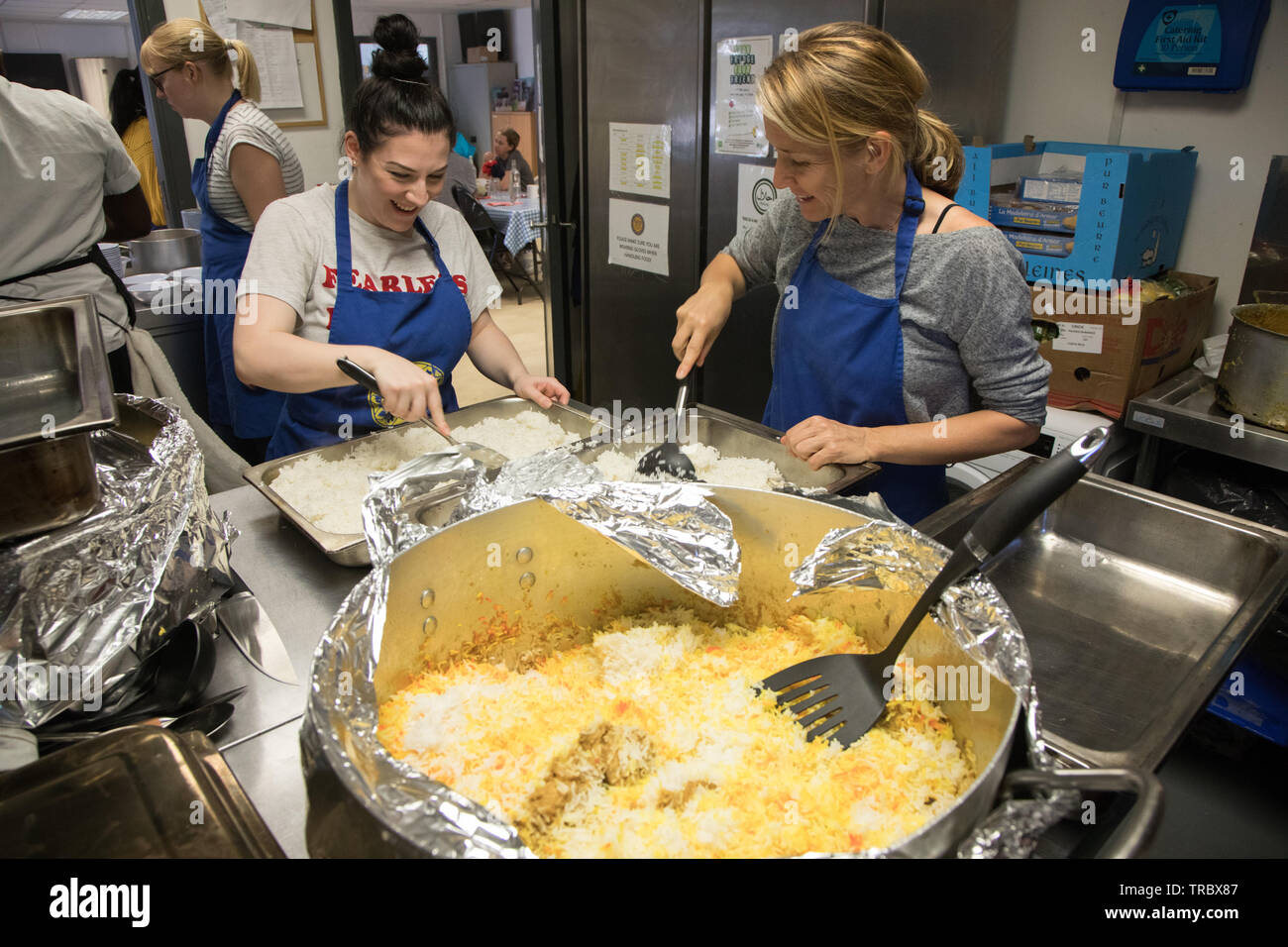 Volunteers at a community kitchen prepare a meal for diners in need. Stock Photo
