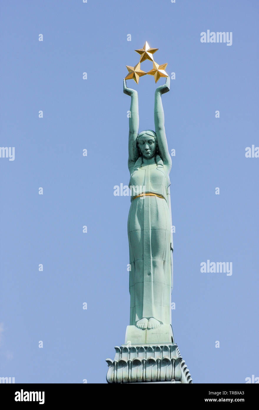 The copper statue of Liberty holding three gold stars on top of the Latvian Freedom Monument in Riga, Latvia. Stock Photo