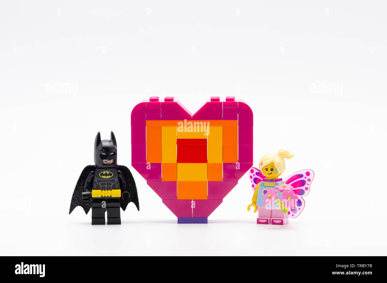 lego batman with butterfly girl and piece offering heart shape.  Lego minifigures are manufactured by The Lego. Stock Photo