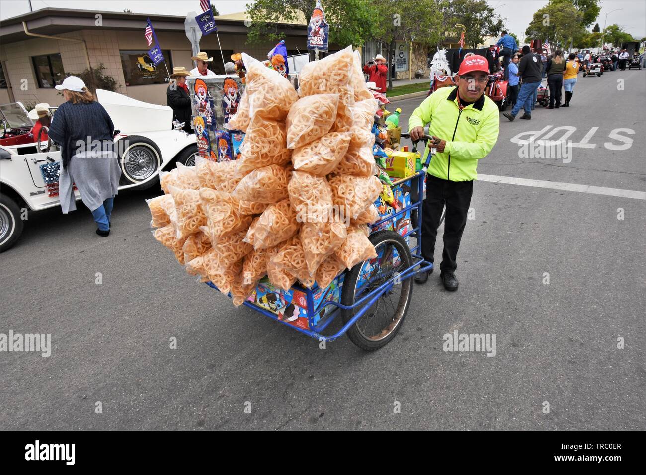Senior Street vendor selling real Mexican Latin type of  snacks to parade participants and goers before start in California USA America Stock Photo
