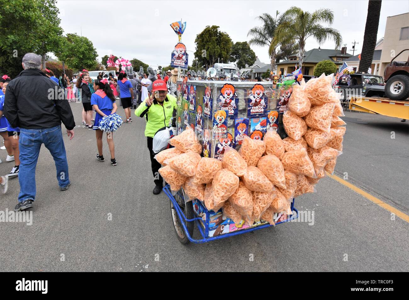 Senior Street vendor selling real Mexican Latin type of  snacks to parade participants and goers before start in California USA America Stock Photo