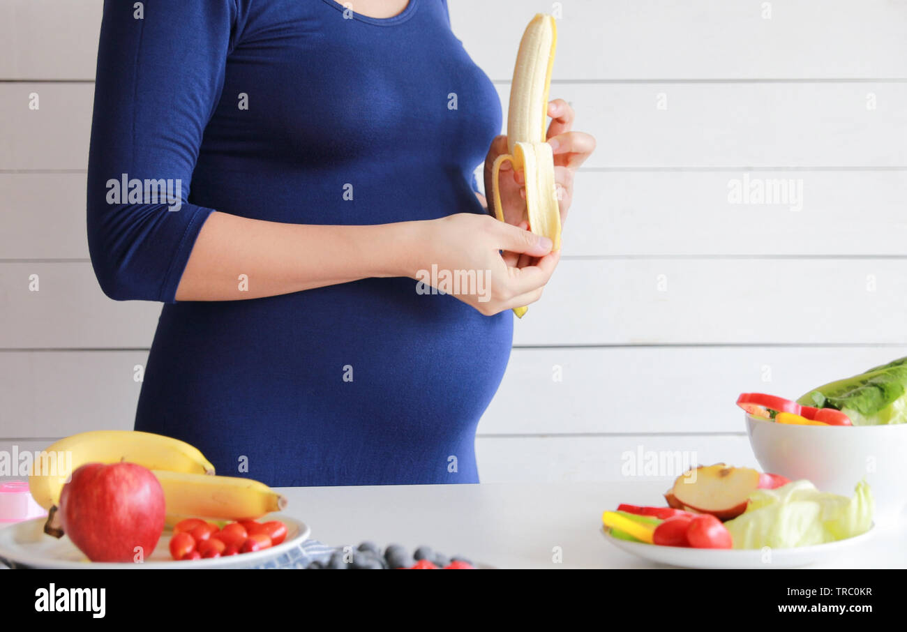 Pregnant woman eat vegetable salad, fruit, juice, milk, healthy food Stock Photo